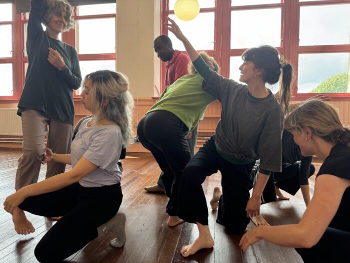 Group of dancers explore creative movement in a bright lit studio.